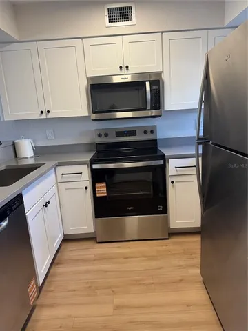 a kitchen with cabinets and steel stainless steel appliances
