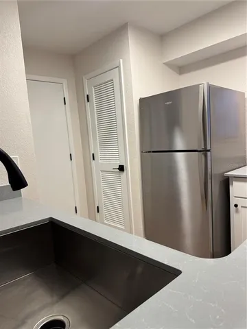 a view of kitchen with refrigerator and wooden floor