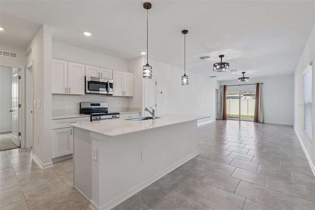 1723 Foreman Road Eagle Lake, FL 33839 - Photo 14 of 34 a kitchen with kitchen island a sink stainless steel appliances and cabinets