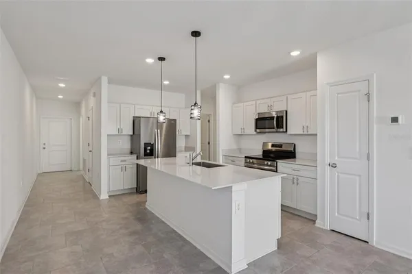 a kitchen that has a sink a stove and stainless steel appliances