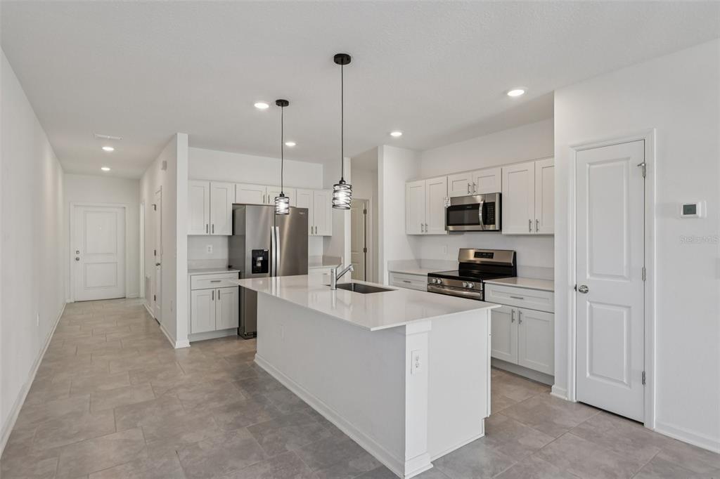 1723 Foreman Road Eagle Lake, FL 33839 - Photo 16 of 34 a kitchen with white cabinets and stainless steel appliances