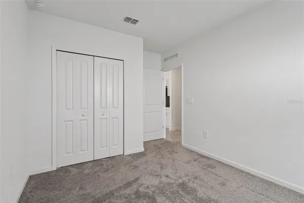 an empty room with windows and closet