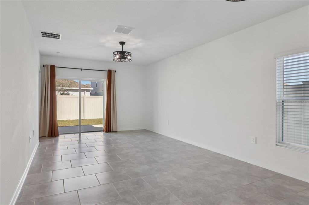 1723 Foreman Road Eagle Lake, FL 33839 - Photo 9 of 34 a view of a hallway with a chandelier fan and windows