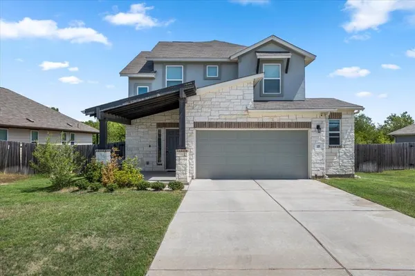 a front view of a house with a garden and plants