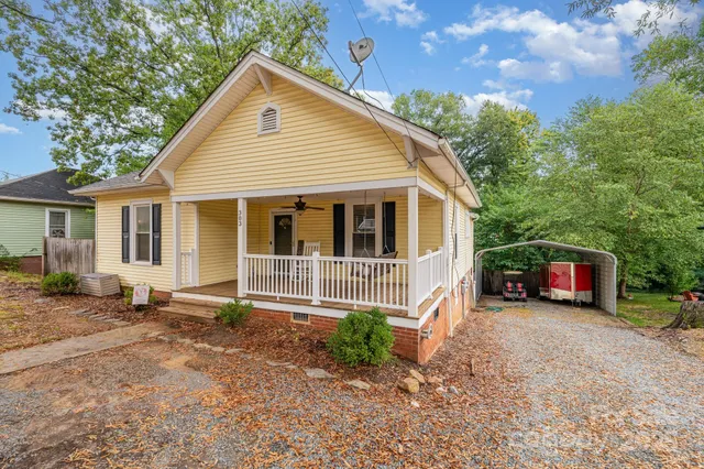 a view of a house with a yard and wooden fence
