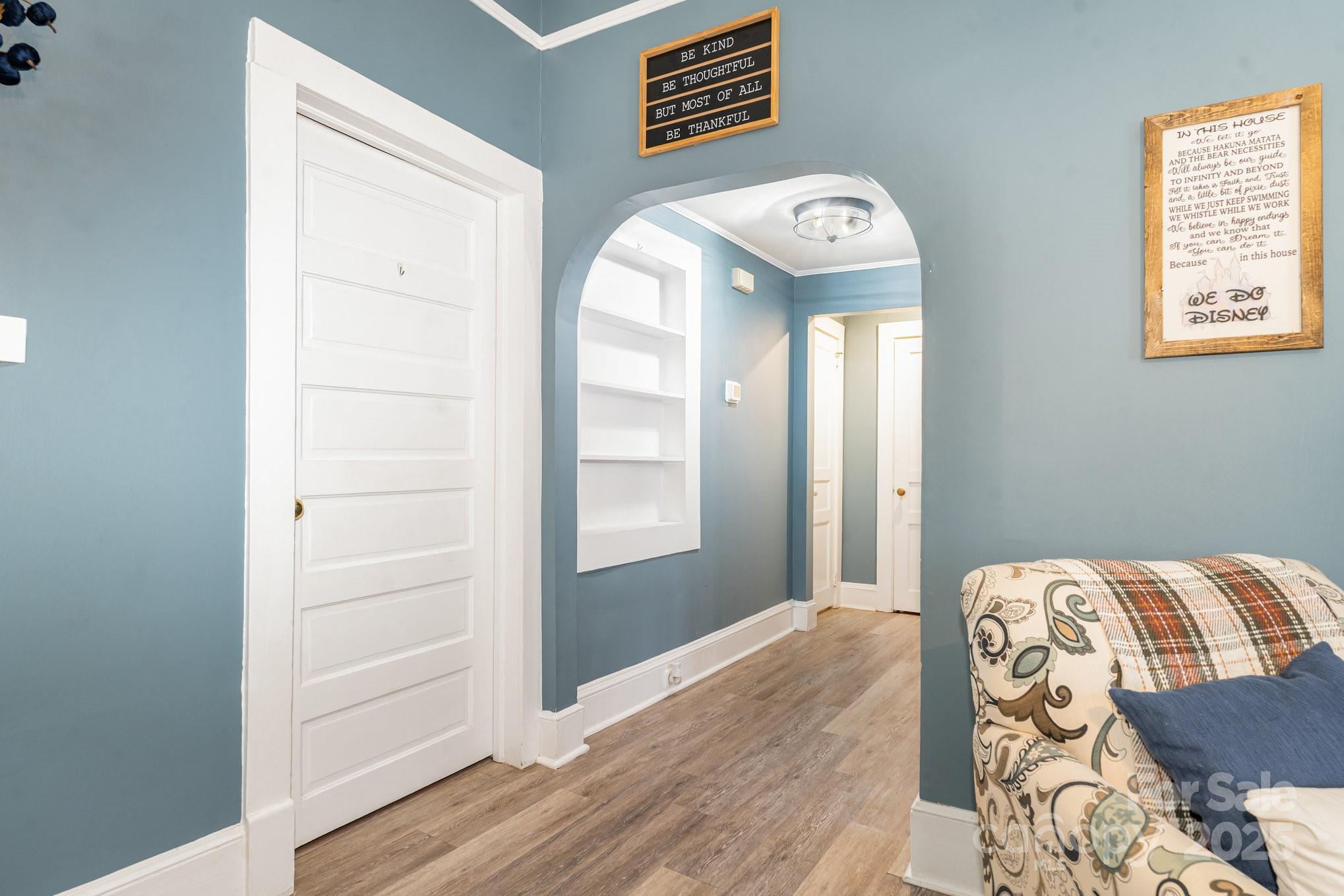 303 East 4th Street Kannapolis, NC 28083 - Photo 7 of 19 a view of a hallway to a livingroom with wooden floor and a window