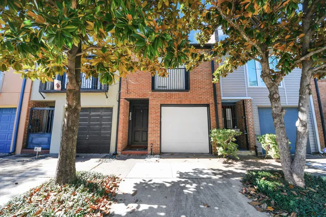 a front view of a house with a tree
