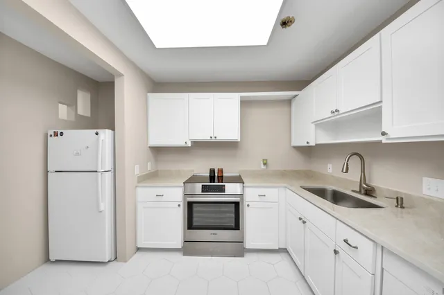 a kitchen with white cabinets and white appliances