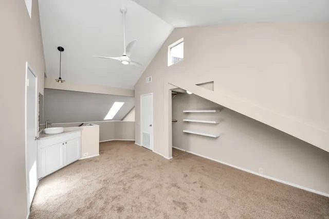 a view of an empty room and a kitchen