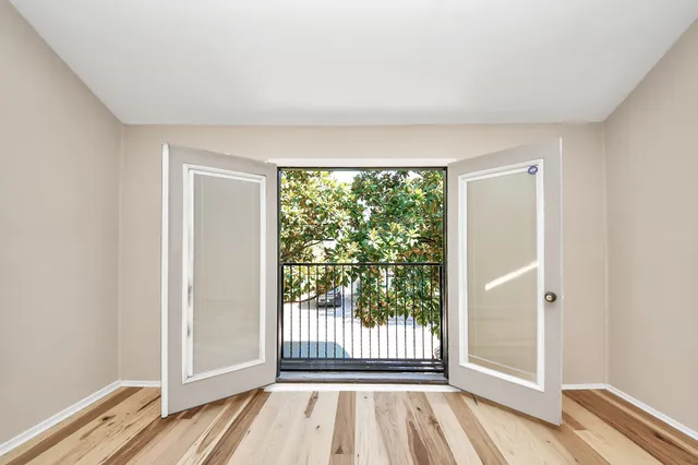 a view of a room with wooden floor and a floor to ceiling window