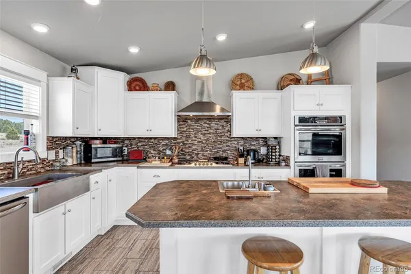 a kitchen with kitchen island granite countertop a sink and a stove