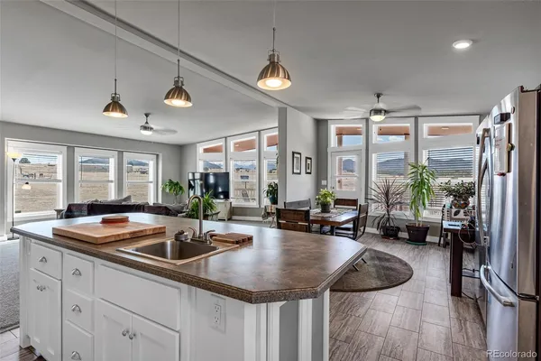 a kitchen with sink refrigerator and large windows