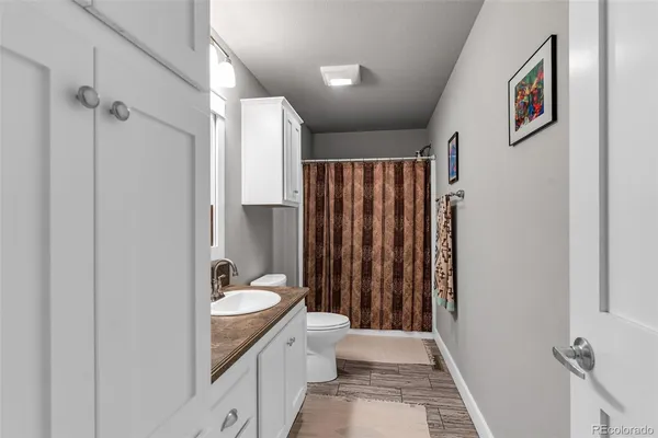 a bathroom with a granite countertop sink toilet and shower