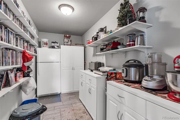 a kitchen with a refrigerator and white cabinets