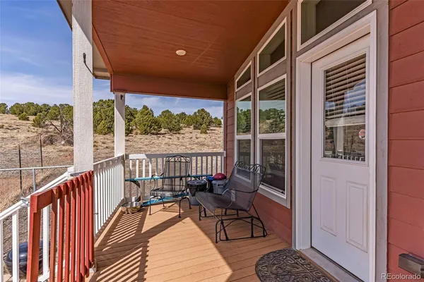 a balcony with wooden floor and outdoor seating