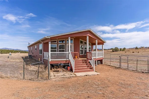 a view of a house with wooden deck and a big yard