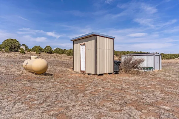 a view of a dry yard with wooden fence