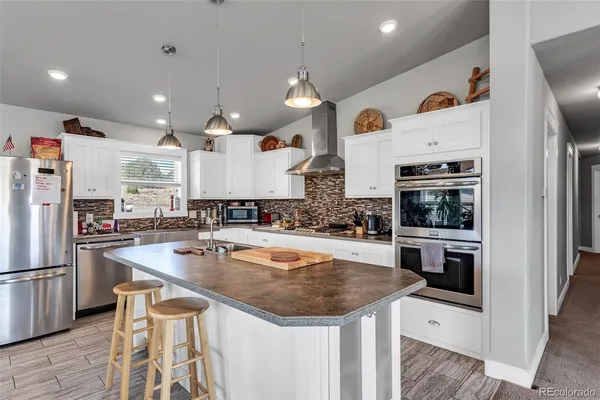 a kitchen with stainless steel appliances granite countertop a sink and a refrigerator