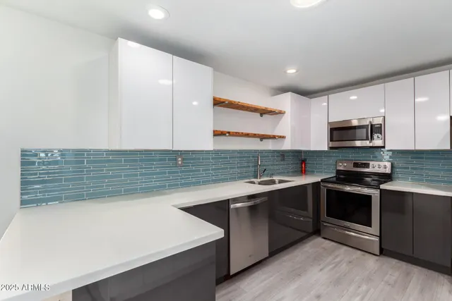 a kitchen with stainless steel appliances granite countertop a sink and stove top oven