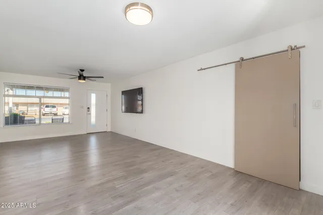 an empty room with wooden floor and windows