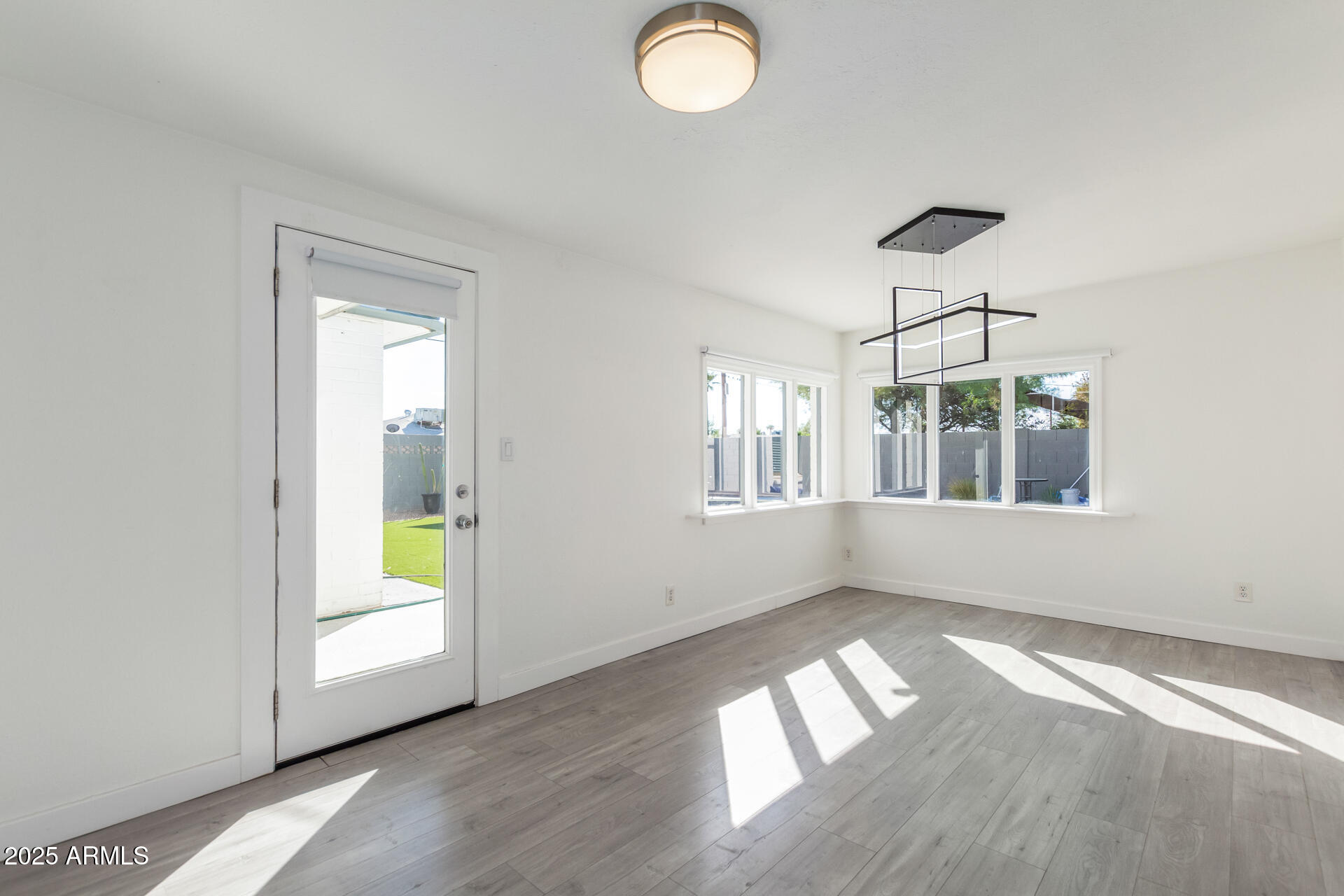 3329 East Palm Lane Phoenix, AZ 85008 - Photo 9 of 45 an empty room with wooden floor and windows
