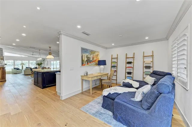 a view of a room with lots of furniture and hardwood floor