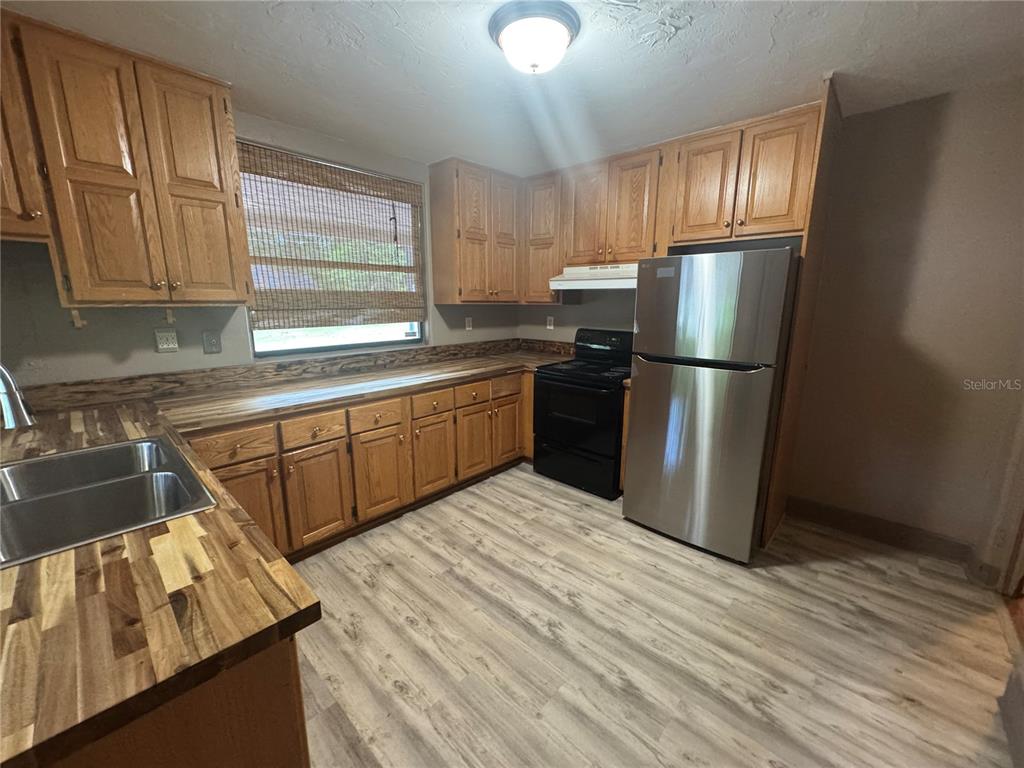3 Northwest 24 Street Gainesville, FL 32607 - Photo 5 of 22 a kitchen with stainless steel appliances granite countertop a refrigerator sink and cabinets