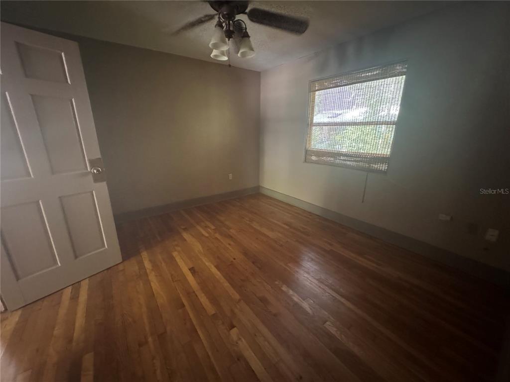 3 Northwest 24 Street Gainesville, FL 32607 - Photo 7 of 22 an empty room with wooden floor fan and windows