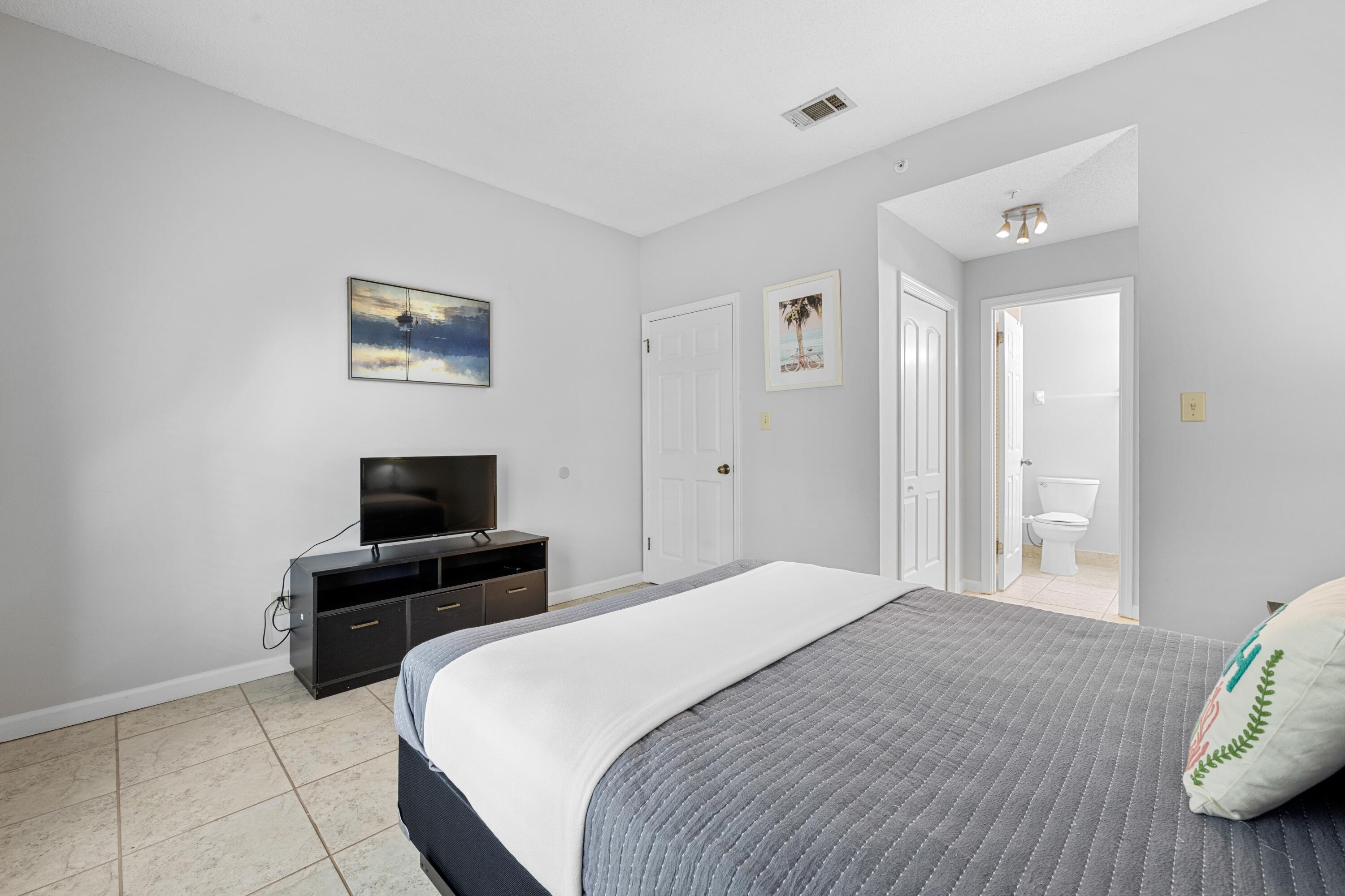 200 Sandestin Lane, Unit 1209 Miramar Beach, FL 32550 - Photo 21 of 30 a bedroom with a bed and a flat screen tv