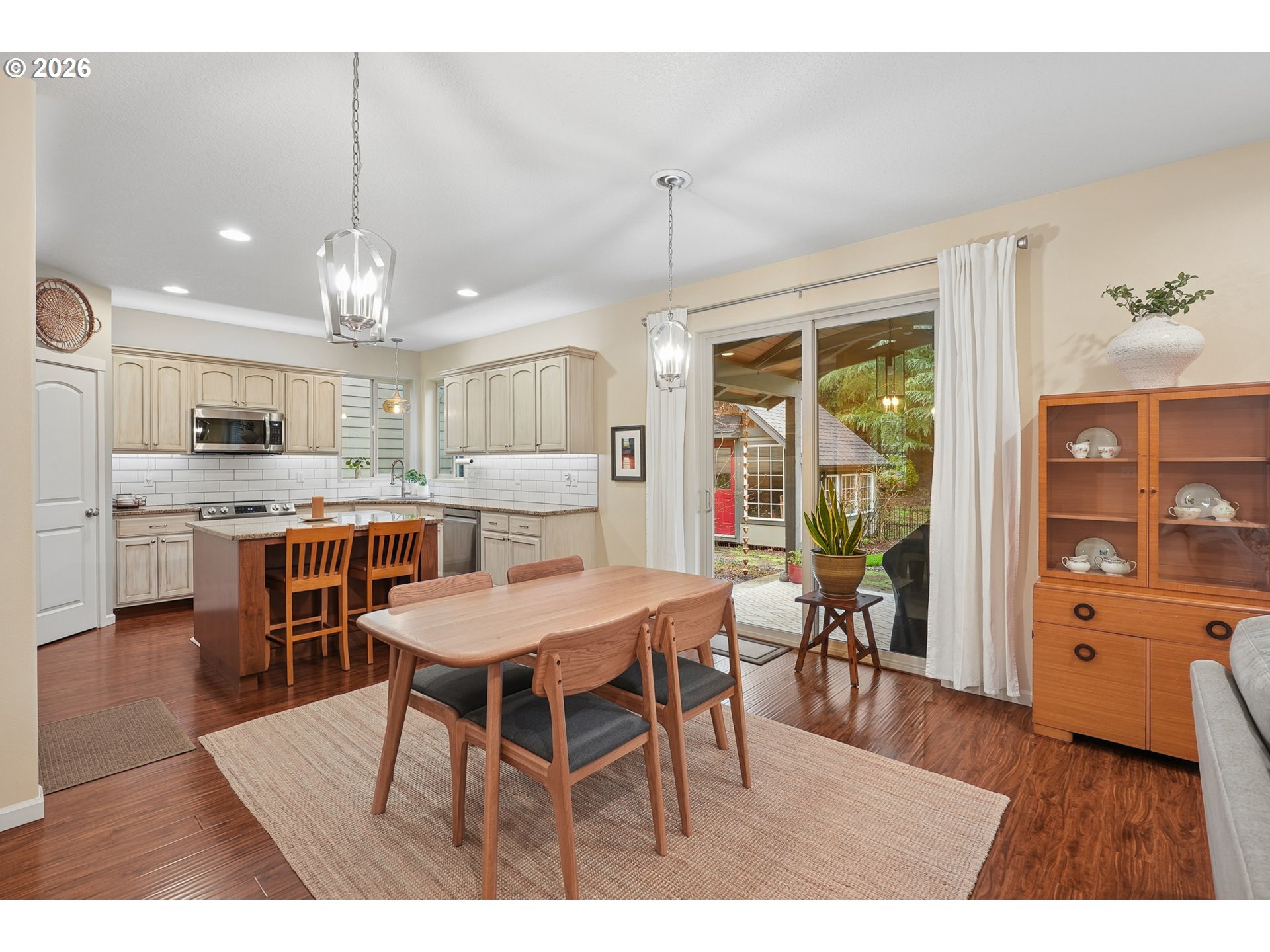 504 North Allen Creek Drive Ridgefield, WA 98642 - Photo 15 of 38 a open kitchen with stainless steel appliances kitchen island granite countertop a dining table chairs and white cabinets