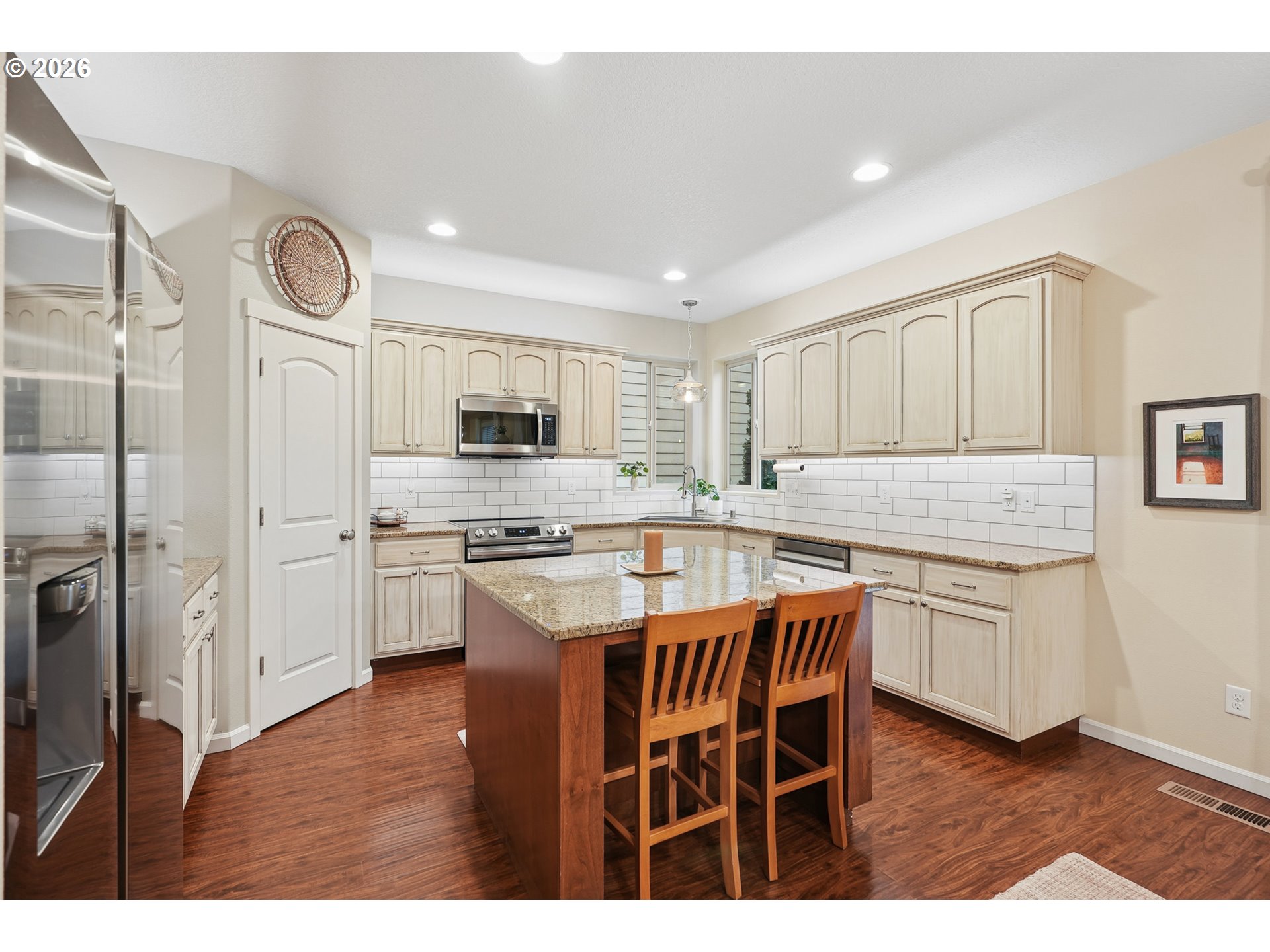504 North Allen Creek Drive Ridgefield, WA 98642 - Photo 18 of 38 a kitchen with stainless steel appliances granite countertop a stove a sink dishwasher a refrigerator with white cabinets and wooden floor
