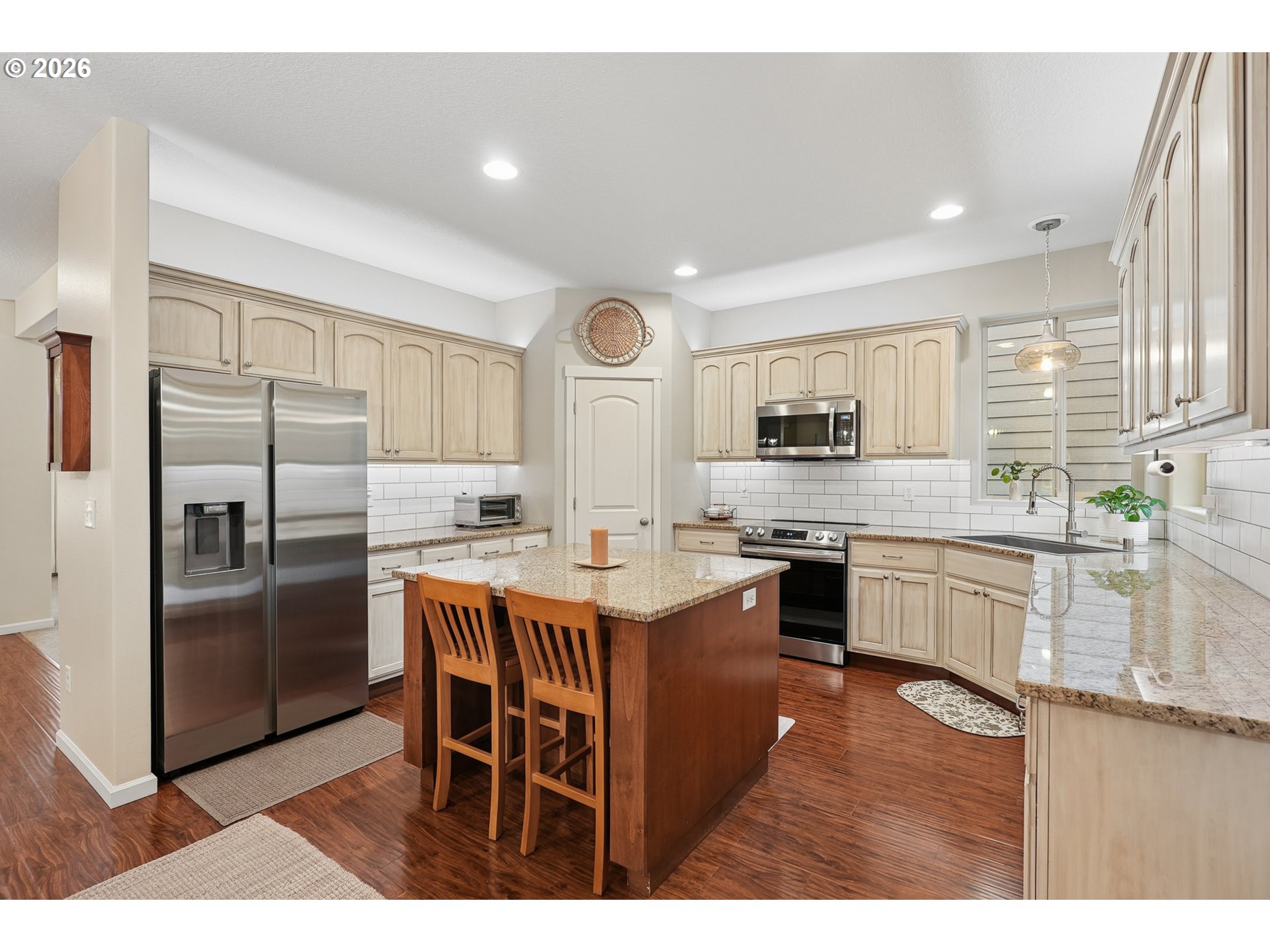 504 North Allen Creek Drive Ridgefield, WA 98642 - Photo 19 of 38 a kitchen with stainless steel appliances granite countertop a stove a sink dishwasher a refrigerator and white cabinets with wooden floor