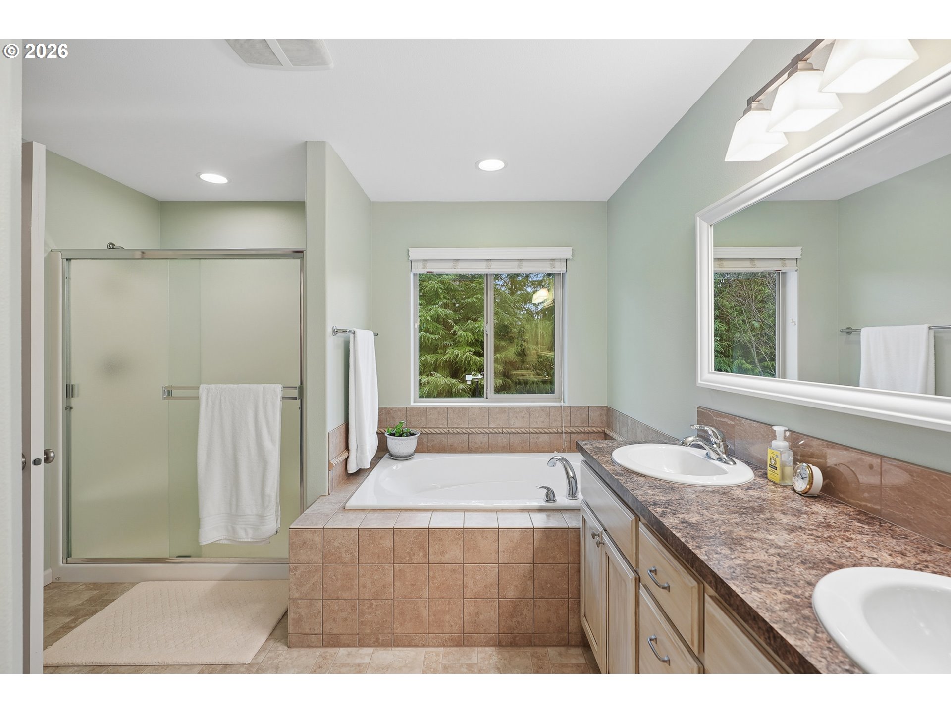 504 North Allen Creek Drive Ridgefield, WA 98642 - Photo 26 of 38 a bathroom with a granite countertop sink a large mirror and a bathtub