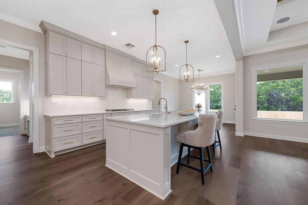8005 Bee Cave Road China Spring, TX 76633 - Photo 14 of 40 Kitchen featuring a chandelier, crown molding, light countertops, tasteful backsplash, and dark wood-type flooring