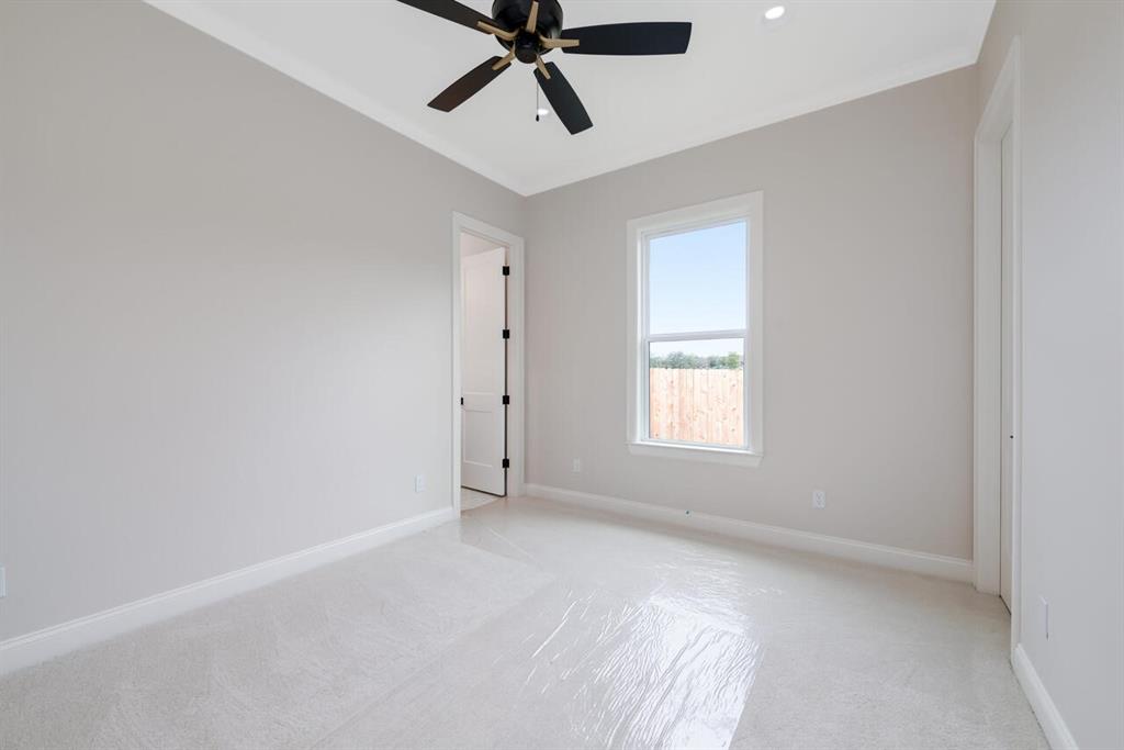 8005 Bee Cave Road China Spring, TX 76633 - Photo 36 of 40 Empty room with light carpet, ceiling fan, and ornamental molding