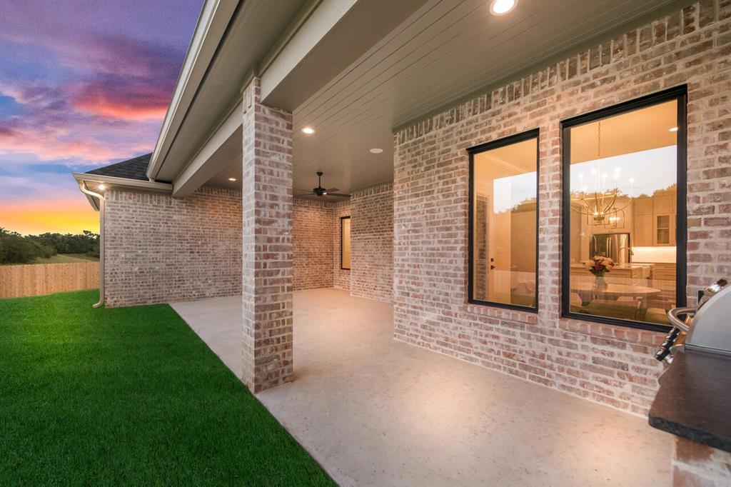 8005 Bee Cave Road China Spring, TX 76633 - Photo 7 of 40 Patio terrace at dusk with ceiling fan, a patio area, a lawn, and area for grilling