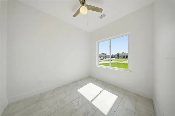an empty room with yellow walls and windows