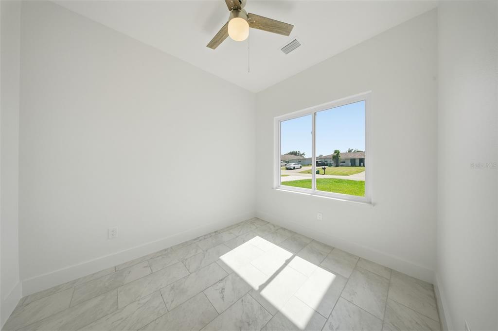 10458 Pendleton Avenue Englewood, FL 34224 - Photo 25 of 30 an empty room with yellow walls and windows
