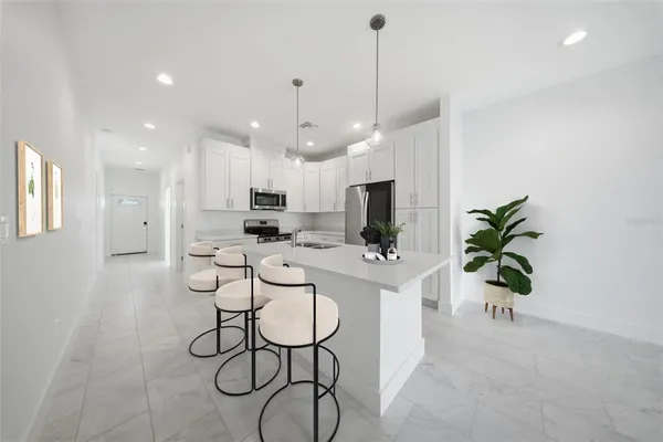 a view of kitchen with sink and refrigerator