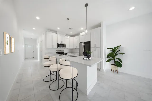 a view of kitchen with sink and refrigerator