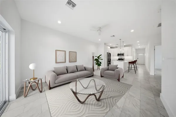 a living room with furniture and a dining table with wooden floor