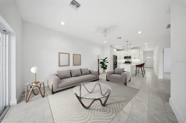 a living room with furniture and a dining table with wooden floor