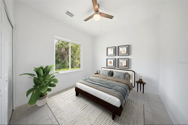 a bedroom with a bed and a potted plant