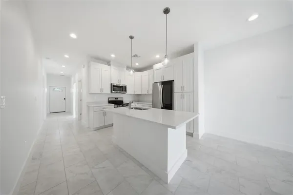 a kitchen with white cabinets and stainless steel appliances