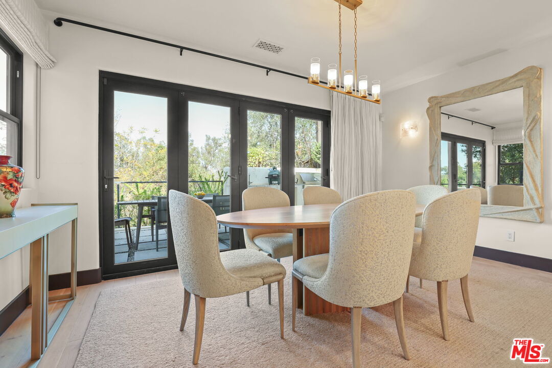 2835 Oak Point Drive Los Angeles, CA 90068 - Photo 17 of 50 a dining room with furniture a chandelier and wooden floor