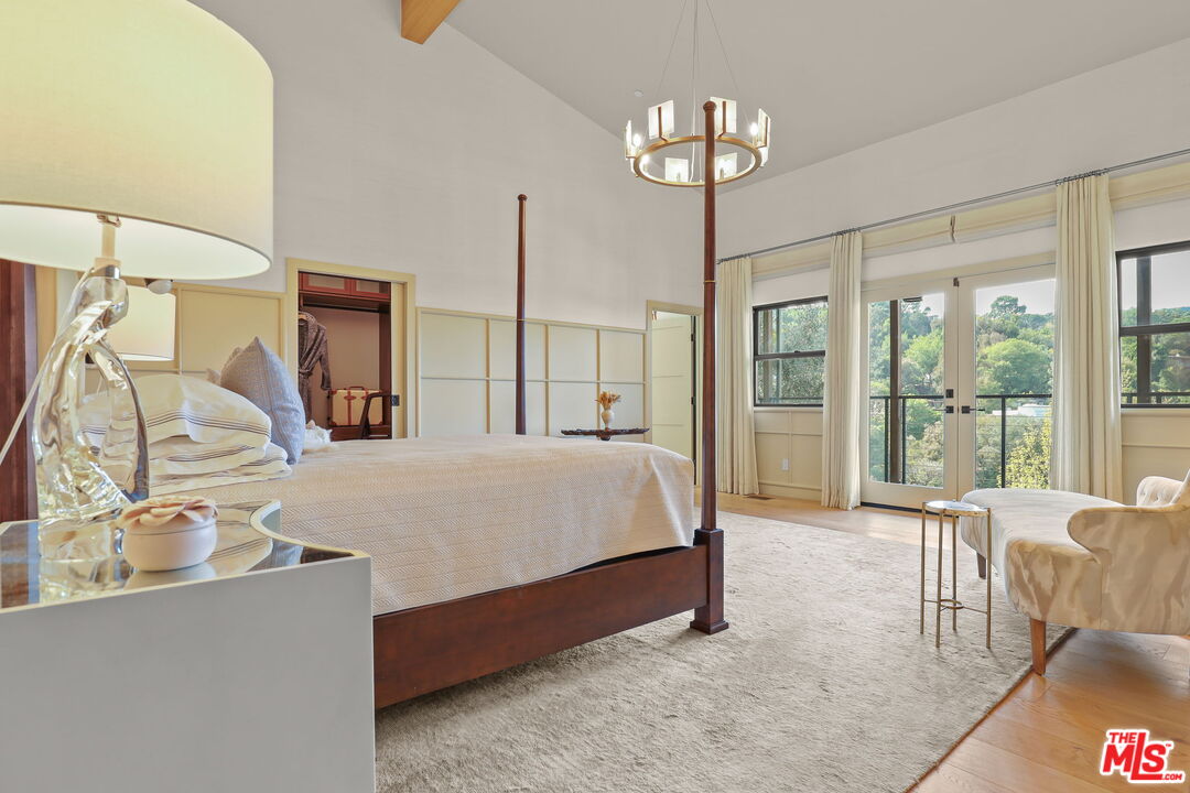 2835 Oak Point Drive Los Angeles, CA 90068 - Photo 18 of 50 a spacious bedroom with a large bed and a chandelier