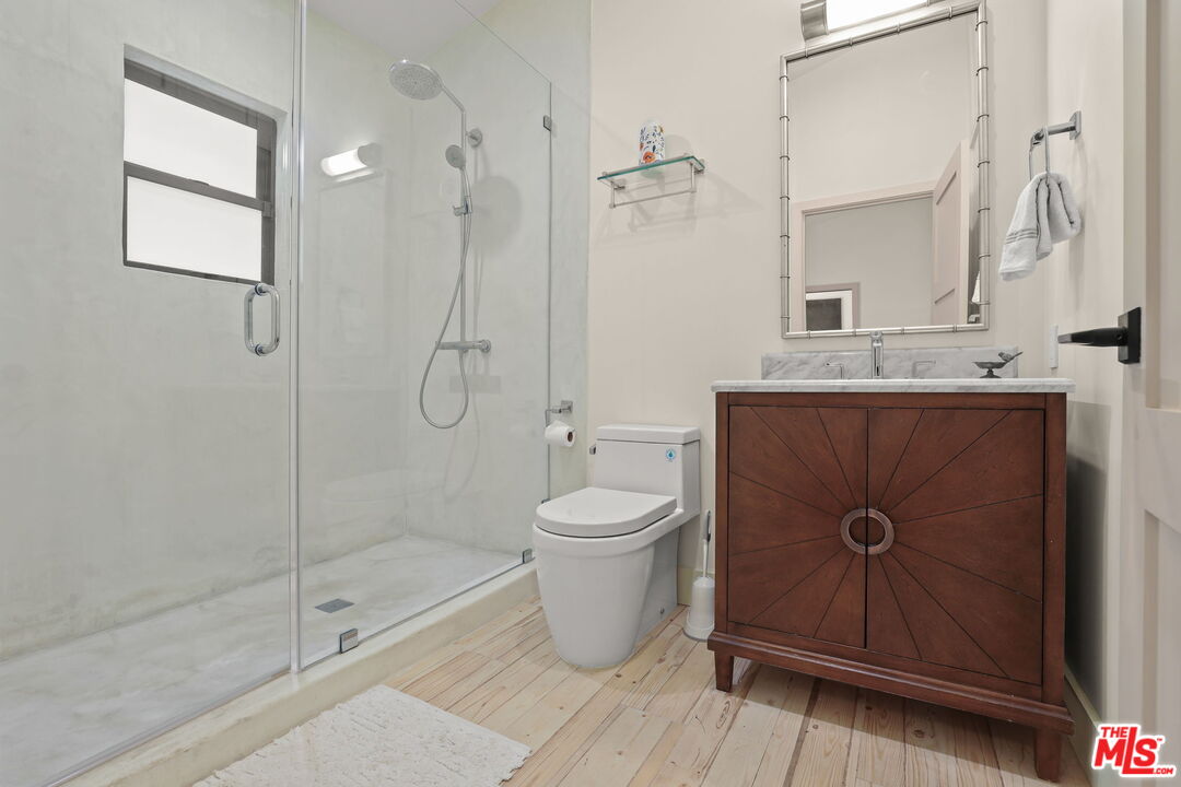 2835 Oak Point Drive Los Angeles, CA 90068 - Photo 25 of 50 a bathroom with a granite countertop toilet a sink and a mirror