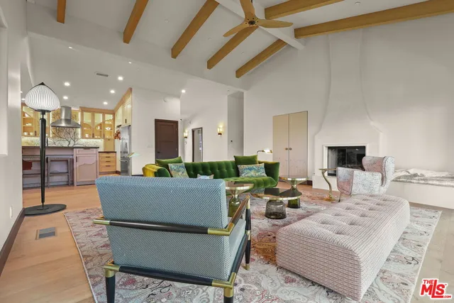 a living room with furniture a flat screen tv and kitchen view