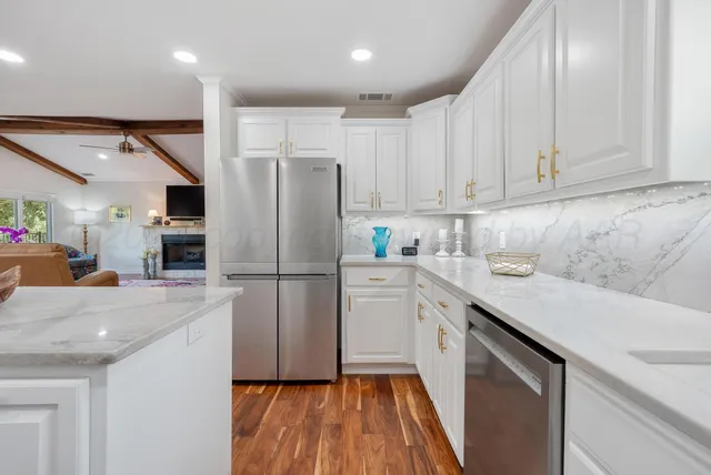 a kitchen with a sink a refrigerator a microwave and cabinets