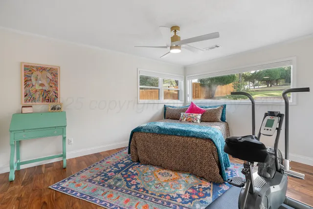 a bedroom with a bed mirror and a window
